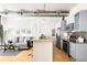 Living area connected to a modern kitchen with stainless appliances and bar seating at 3100 Huron St # 1B, Denver, CO 80202