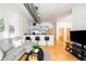 Open floor plan living room featuring hardwood floors and a modern kitchen bar area at 3100 Huron St # 1B, Denver, CO 80202