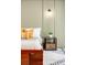 Close up of a modern bed frame with stylish yellow pillows and a dark wood night stand at 3100 Huron St # 1B, Denver, CO 80202
