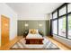 Modern bedroom with unique bed frame, area rug, and a large window at 3100 Huron St # 1B, Denver, CO 80202