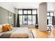 Spacious main bedroom with large window, wood floors, and stylish decor at 3100 Huron St # 1B, Denver, CO 80202