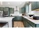 Green kitchen featuring stainless steel appliances, quartz counters, and wood floors at 4261 Ridgewalk Pt, Castle Rock, CO 80108