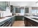 Well-lit kitchen showcases dark green cabinetry, white countertops and stainless steel appliances at 4261 Ridgewalk Pt, Castle Rock, CO 80108