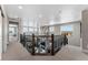 Upstairs landing with carpet, decorative railing, and view to the open-concept main floor and outdoor views at 4261 Ridgewalk Pt, Castle Rock, CO 80108