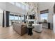 Bright living room features a tall fireplace, large windows offering scenic views, and modern decor at 4261 Ridgewalk Pt, Castle Rock, CO 80108