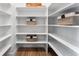 Organized pantry with white shelves, baskets, and light wood-look floors at 4261 Ridgewalk Pt, Castle Rock, CO 80108