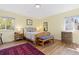 A cozy bedroom features a wooden bed frame, a patterned bench, and warm, inviting yellow walls at 15000 W 29Th Ave, Golden, CO 80401