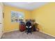 Bedroom with yellow walls configured as an office with a window overlooking the backyard at 15000 W 29Th Ave, Golden, CO 80401
