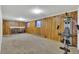 Spacious carpeted basement with wood paneled walls, brick fireplace, and exercise equipment at 17825 E Carolina Pl, Aurora, CO 80017