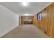 Spacious basement featuring wood paneling, brick fireplace, and neutral carpet at 17825 E Carolina Pl, Aurora, CO 80017