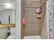 Tiled shower stall with shower head, toiletry shelves, and decorative curtain at 17825 E Carolina Pl, Aurora, CO 80017