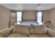 Bedroom features a large bed, a couch and soft natural light from windows at 17825 E Carolina Pl, Aurora, CO 80017
