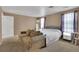 Neutral bedroom featuring a comfortable sitting area, a bed, and ample natural light at 17825 E Carolina Pl, Aurora, CO 80017