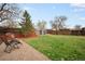 Spacious backyard with lush lawn, mature trees, shed, and stone landscaping, offers ample space for outdoor activities at 3308 E 118Th Way, Thornton, CO 80233