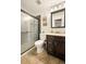 A well-lit bathroom features a sliding glass shower door and a dark wood vanity with a mirror at 3308 E 118Th Way, Thornton, CO 80233