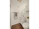 Compact bathroom with white fixtures, modern lighting, and wood-look flooring, maximizing space and style at 3308 E 118Th Way, Thornton, CO 80233