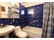 Classic bathroom with blue tiled walls and floor, a white bathtub, a toilet, and a sink at 446 Blue River Rd, Breckenridge, CO 80424