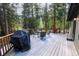 Spacious outdoor deck area features a grill, seating for four, and surrounding forest views at 446 Blue River Rd, Breckenridge, CO 80424