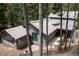 Aerial view showcases the home's roof, siding, decks, and placement amongst the tall trees at 446 Blue River Rd, Breckenridge, CO 80424