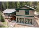 Mountain home with a two-car garage, deck, and forest surroundings at 446 Blue River Rd, Breckenridge, CO 80424