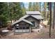 Aerial view of a cozy home nestled amongst tall trees, complemented by a lovely porch at 446 Blue River Rd, Breckenridge, CO 80424