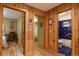 Hallway leads to a bedroom, bathroom, and other rooms, all featuring wood paneled walls and hardwood floors at 446 Blue River Rd, Breckenridge, CO 80424