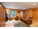 Comfortable living room showcasing wood paneled walls, a stone fireplace with wood-burning stove, and hardwood floors at 446 Blue River Rd, Breckenridge, CO 80424