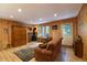 Comfortable living room featuring wood paneled walls, a stone fireplace with wood-burning stove, and hardwood floors at 446 Blue River Rd, Breckenridge, CO 80424