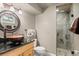 Bathroom featuring a stone vessel sink, granite countertop, and tiled shower with glass door at 6530 Ridgeview Dr, Morrison, CO 80465