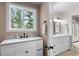 Bright bathroom featuring double sinks with marble countertops and modern fixtures with a window view at 6530 Ridgeview Dr, Morrison, CO 80465