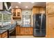 Charming kitchen featuring wood cabinets, granite countertops, and modern appliances at 6530 Ridgeview Dr, Morrison, CO 80465
