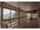 Covered porch with wooden deck and railing overlooking a mountain vista at 6530 Ridgeview Dr, Morrison, CO 80465