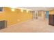 Spacious basement with carpet flooring, built-in shelves, and a large window at 6684 E Bates Ave, Denver, CO 80224