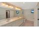 Bathroom featuring double sinks, a large mirror, a toilet, a bidet, and a wall-mounted TV at 6684 E Bates Ave, Denver, CO 80224
