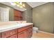 Bathroom with a dark wood vanity, marble countertop, stylish fixtures, and a built-in mirror cabinet at 6684 E Bates Ave, Denver, CO 80224