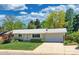 Charming ranch-style home featuring a well-manicured lawn, mature trees, and a spacious driveway and garage at 6684 E Bates Ave, Denver, CO 80224