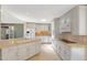 Spacious kitchen featuring white cabinets, ample counter space, and modern appliances at 6684 E Bates Ave, Denver, CO 80224