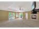 Spacious living room featuring a fireplace, a ceiling fan, and multiple windows and doors for abundant natural light at 6684 E Bates Ave, Denver, CO 80224