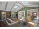 Bright living room featuring vaulted ceilings with skylights, hardwood floors, and views into the kitchen and dining area at 6684 E Bates Ave, Denver, CO 80224