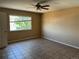 This vacant bedroom features tile floors, neutral walls, a ceiling fan, and a window with a view at 20787 E 39Th Ave, Denver, CO 80249