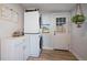 Convenient laundry area with stacked washer and dryer, storage cabinet and a decorative hanging plant at 1947 Jay St, Lakewood, CO 80214