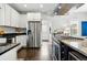 Bright kitchen featuring stainless steel appliances, granite counters, and white cabinetry at 2716 N Columbine St, Denver, CO 80205