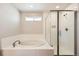 Bright bathroom featuring a soaking tub, glass enclosed shower and tiled walls at 4327 Wilson Peak Dr, Castle Rock, CO 80104