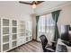 Office space with built-in shelving, a ceiling fan, wood floors, and a modern desk facing a bright window at 4327 Wilson Peak Dr, Castle Rock, CO 80104