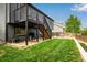 Backyard featuring a deck, stairs, and a green lawn, providing ample space for outdoor activities at 19661 E Girard Ave, Aurora, CO 80013