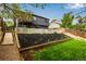 Landscaped backyard with a wooden bridge, stairs, planting beds, and lush green lawn, offering serene outdoor space at 19661 E Girard Ave, Aurora, CO 80013