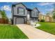 Inviting two-story home with gray siding and black trim and shutters along with manicured lawn at 19661 E Girard Ave, Aurora, CO 80013