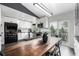Bright kitchen with white cabinets, subway tile backsplash, and a spacious wooden dining table at 19661 E Girard Ave, Aurora, CO 80013