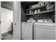 Clean laundry room with modern washer and dryer and storage shelves at 19661 E Girard Ave, Aurora, CO 80013