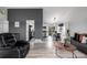 Open-concept living room showcasing gray walls, laminate flooring, and furniture with a peek into the kitchen at 19661 E Girard Ave, Aurora, CO 80013